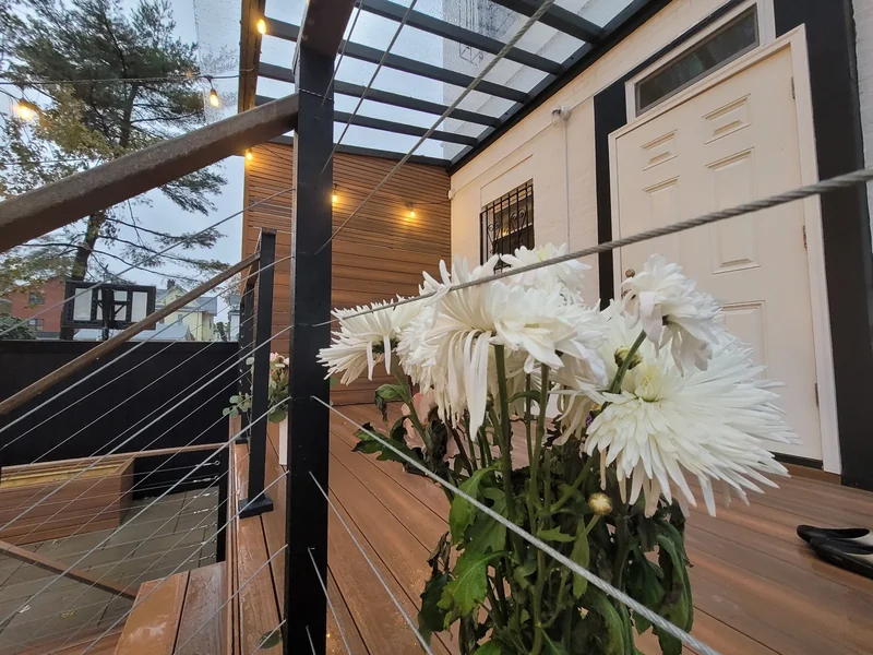 A closer look at the decking, cable railing and overhead structure.